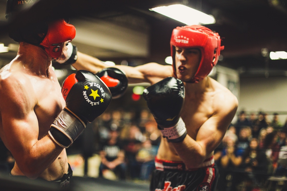 Two boxers in protective gear, fighting